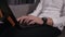 Aimed footage of man`s hands typing on laptop. Wearing black stylish handwatches and white shirt. Smiling caucasian man
