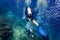 Air bubbles emerging from diver at coral reef under water