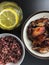 Air fried chicken wings on ceramic dish serve with small bowl of cooked Riceberry and a glass of Iced green tea topped with slice