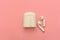 Air Pods. wireless headphones and wireless charging Case on pink background. Copy Space