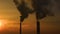Air pollution. clouds of smoke coming from the chimneys of the plant with beautiful golden yellow lighting of setting sun. Drone f