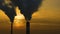 Air pollution. clouds of smoke coming from the chimneys of the plant with beautiful golden yellow lighting of setting sun. Drone f