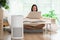 air purifier in living room for clean and fresh air with woman working with computer laptop