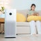 Air Purifier with woman relax and use tablet on sofa. Purification system for filter and cleaning dust PM2.5 HEPA and virus in