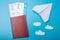 Air tickets with passport and paper plane on blue background, to