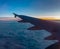 Air Travel Concept. Air Plane Wing Above The Soft Cotton Cloud During Sunrise