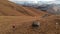 Air view. Girl traveler with a camera on her neck walking along the slope with yellow grass against the backdrop of