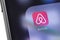 Airbnb icon on the screen smartphone. Airbnb - service for booking rooms, enabling people to lease or rent short-term lodging. Mo