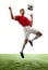 Airborne Mastery. Portrait of soccer as professional player executes flawless mid-air kick, sending ball soaring against
