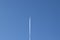 Aircraft in blue sky leaving trace. Global warming and chemtrail conspiracy. Copy space near airplane. Air traffic and