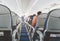 Aircraft cabin after take off. inside the plane. passengers sit on the seat in the cabin ECOM class in Boeing. the passage between