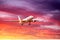 Aircraft on the glide slope before landing on the background of a beautiful sunset and picturesque clouds