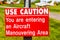 Aircraft manouvering red and white warning sign hung on post at airstrip.