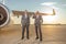 Aircraft pilots standing near airplane engine at airfield