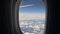 Aircraft porthole. Airplane flight, window view. Wing, blue sky and white clouds