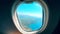 Aircraft porthole with the sea and the land seen from it