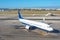 Aircraft stands at the airport parking lot before departure, against the background of the city