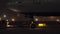 Aircraft towing tractor pulling Boeing 777 at night