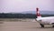 Aircraft tractor towing an airplane. Plane moves along the runway, leaving steam