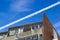 Aircraft vapour trail over an apartment block