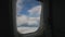 Aircraft Wing of flying in clouds and blue sky airplan. View from passenger porthole windows.