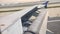 Aircraft wing outside board aileron lifting up for maneuvering speed while take off at the airport.