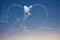 Aircrafts aerobatic plane drawing heart figure in the sky