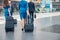 Aircrew members carrying travel suitcases in airport terminal