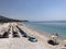 Aireal view with umbrellas and sun beds in a rocky beach in Albania.