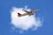 An airline plane in the blue sky flying in front of a big white cloud. Image with copy space
