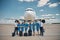 Airline workers with travel suitcases standing outdoors in airfield