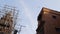 Airliner flies over a construction scaffold and residential houses