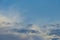 Airliner flying over dark, grey and white rain clouds in bright sunlight in autumn