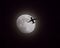 Airliner Passing in Front of Moon at Night