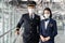 Airliner pilot and air hostess wearing face mask walking in airport terminal to the airplane during the COVID pandemic to prevent