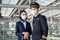 Airliner pilot and air hostess wearing face mask walking in airport terminal to the airplane during the COVID pandemic to prevent