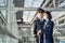 Airliner pilot and air hostess wearing face mask walking in airport terminal to the airplane during the COVID pandemic to prevent