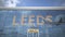 Airliner reflecting in the windows of airport terminal with LEEDS text. 3d rendering