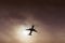 Airliner silhouette visible under a gash in the clouds