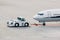 Airplane on airport runway with pushback tractor