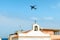 Airplane in the blue sky above the church of the Holy Souls in Terrasini province of Palermo, Sicily