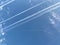 Airplane in the blue sky with clouds from below. High flying passenger plane with condensation trail. Jets flying
