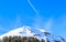Airplane in a blue sky with traces. Mountain Hohe Salve