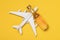 Airplane and bottle of whiskey on a yellow background, top view. Concept on the topic of drunkenness among pilots