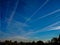 Airplane chemtrails in blue sky