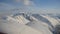 Airplane climbing on blue sky with majestic snowy peaks in the arctic circle