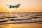 Airplane come down on the land with beach sunset or sunrise