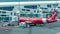 Airplane by company Airasia preparing for departure, jet bridge with passengers