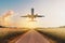 Airplane flying above empty road in rural landscape - travel co