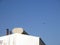 Airplane flying above an industrial shed.